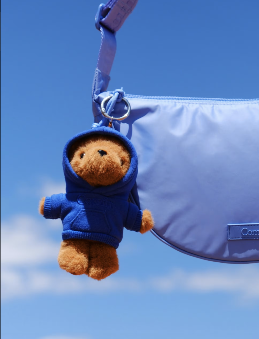 Peluche ourson en hoodie bleu marine Comfrt suspendue à un sac